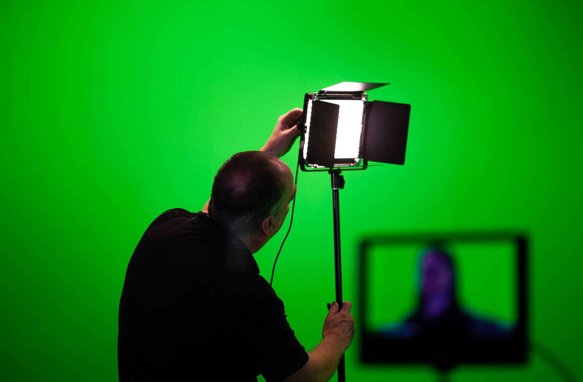 A technician adjusting studio lights